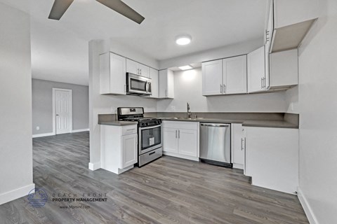 a kitchen with white cabinets and stainless steel appliances